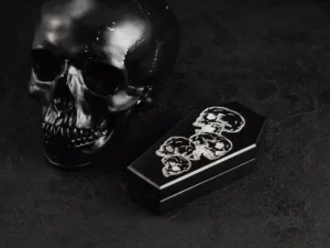 Coffin-shaped dice case with engraved skull design